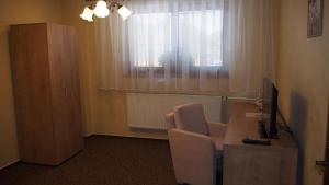 Zimmer mit einem Schreibtisch mit Stuhl und einem Computer in der Unterkunft Hotel Slnecny Dvor in Michalovce