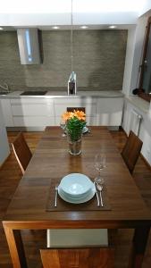 a wooden table with a plate and a vase of flowers at Quiet and spacious apartment with garage option in Krakow