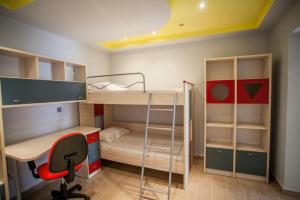 a room with bunk beds and a desk and a chair at Villa Marmari 1 in Marmarion
