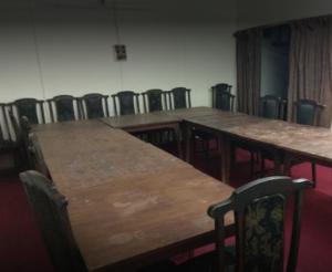 sala konferencyjna z drewnianymi stołami i krzesłami w obiekcie Lourdes Hotel w Kwecie