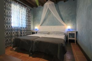 1 dormitorio con 1 cama con 2 mesas y una ventana en El Patio de Fuenteuso, en Villosilla de la Vega