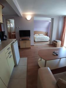 eine Küche und ein Wohnzimmer mit einem Tisch und einem Bett in der Unterkunft Guest House Diamandievi in Nessebar