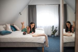 two women sitting on a bed in a bedroom at Fama Residence Gdańsk Old Town in Gdańsk +82 photos
