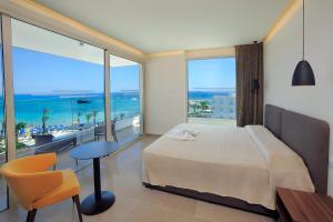 a bedroom with a bed and a view of the ocean at Nelia Beach Hotel & Spa in Ayia Napa