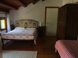 sypialnia z łóżkiem z zagłówkiem kwiatowym i drzwiami w obiekcie Casa vacanze Agli ulivi w mieście Baone