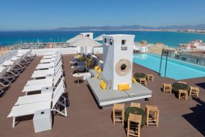 een resort met een zwembad en tafels en stoelen bij whala!fun in El Arenal