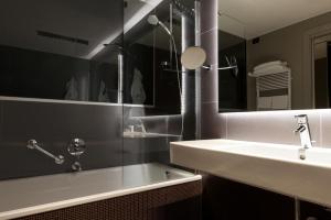 a bathroom with a sink and a mirror and a tub at Hotel Manin in Milan