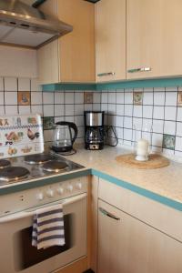 uma cozinha com uma placa de fogão e um forno com uma toalha em Fewo Sonnen Gruss em Krummhörn