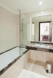 a bathroom with a tub and a glass shower at Palm Appart Club Marrakesh in Marrakesh