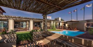 a backyard with a swimming pool and patio furniture at Kathu Inn in Kathu