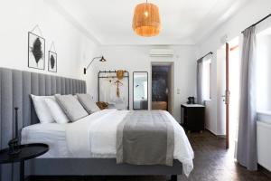 Un dormitorio con una gran cama blanca y una lámpara en Petit Palace Suites en Fira