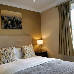 a bedroom with a bed and a painting on the wall at Pinfield Boutique Hotel in Slough