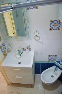 uma casa de banho com um lavatório, um WC e um espelho. em LA SCALINATELLA -vista mare- em Vietri