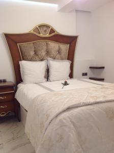 - une chambre avec un grand lit et une tête de lit en bois dans l'établissement Apartamento Daniela, à Benidorm