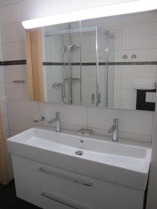 a bathroom with a white sink and a mirror at am Bärgbach DG in Bettmeralp