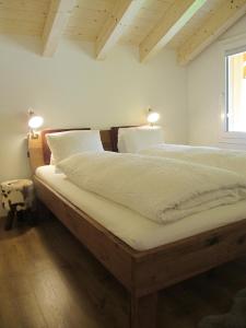 a bedroom with two beds with white sheets and a window at am Bärgbach DG in Bettmeralp