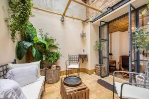 a patio with plants and a couch and a table at Trastevere Luxury&Charming Loft with Courtyard in Rome