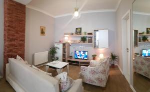 uma sala de estar com um sofá e cadeiras e uma televisão em Mtatsminda em Tbilisi