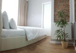 Un dormitorio con una cama blanca y una pared de ladrillo. en Mtatsminda, en Tiflis