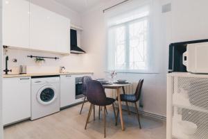 eine Küche mit einem Tisch und Stühlen sowie einer Waschmaschine in der Unterkunft Altair apartment by People Rentals in Bilbao