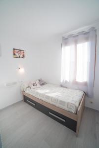 ein Schlafzimmer mit einem Bett in einem Zimmer mit einem Fenster in der Unterkunft Vistas al mar y la piscina in Arenal d'en Castell