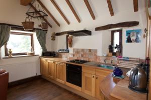 a kitchen with wooden cabinets and a stove top oven at SWALLOWS RETURN in Hartington