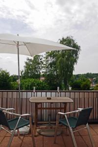 une table et deux chaises avec un parasol dans l'établissement Apartment Fewo Central, à Essen