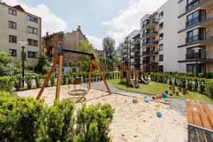 a playground with a swing set in a park at Apartments Kraków Przedwiośnie by Renters in Krakow