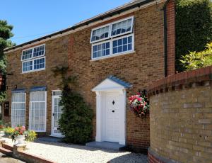 a brick house with a white door and windows at Pinfield Boutique Hotel in Slough