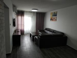 a living room with a black leather couch and a table at lake view in Tiberias