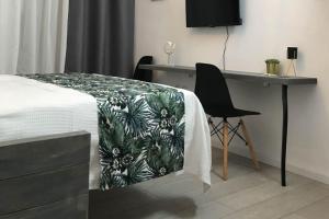 ein Schlafzimmer mit einem Bett, einem Schreibtisch und einem Stuhl in der Unterkunft stuDio 57 II in Alexandroupoli