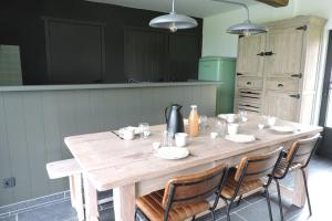 een houten tafel in een keuken met stoelen eromheen bij Op 't Roth in Oudenaarde