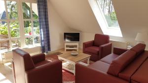 a living room with a couch and two chairs and a tv at Amber Lodge in Seevetal