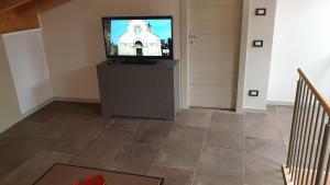 una sala de estar con TV de pantalla plana en una cómoda en Dimora Rosso San Zeno - Wifi veloce e adatto per famiglie, en Verona