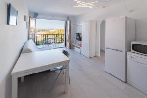 a kitchen with white appliances and a balcony at Vistas al mar y la piscina in Arenal d'en Castell