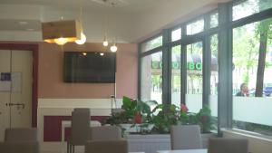 a dining room with tables and chairs and windows at Hotel Colombo in Marghera