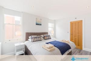a white bedroom with a bed with towels on it at Hill Cottage Apartments Coleshill Open for NEC weekend visitors - Hosted By Coventry Accommodation in Coleshill