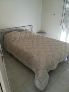a bed with a blanket on the floor in a room at Aub Ptit Confort in Dienville