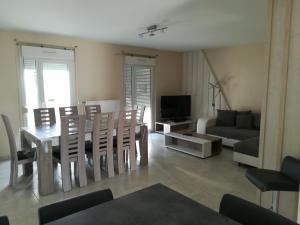 a living room with a table and chairs and a couch at Aub Ptit Confort in Dienville