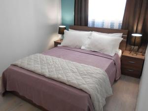 a bedroom with a large bed with purple sheets and white pillows at MiCasa SuCasa / Heart of Athens / Brand-New superlux in Athens