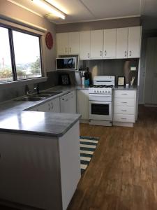 a kitchen with white cabinets and a stove top oven at House on the hill in Port Campbell