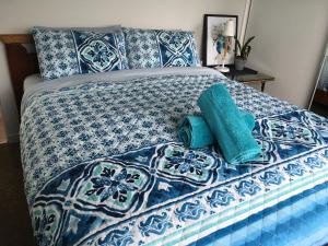 a blue and white bed with two pillows on it at House on the hill in Port Campbell
