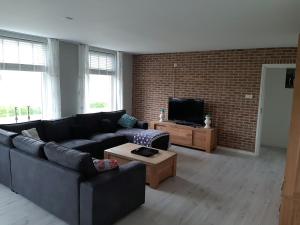 a living room with a couch and a tv at Iefjeshoeve in Petten