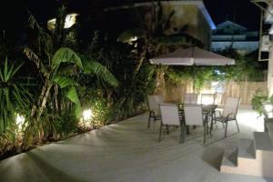 a patio with chairs and tables and umbrellas at night at Sweet Home (50m from center Lithostroto) in Argostoli