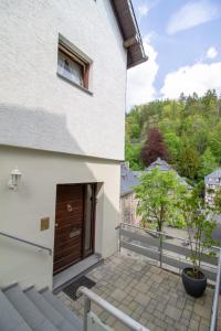 a balcony of a white building with a wooden door at Ferienhaus Mühlenberg in Monschau