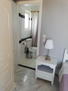 baño con aseo y mesa con lámpara en Seven Seas Apartments, en Artemida 83 fotos más
