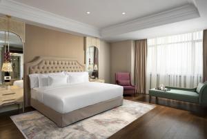 1 dormitorio con 1 cama blanca y 1 silla verde en Barceló Istanbul en Estambul