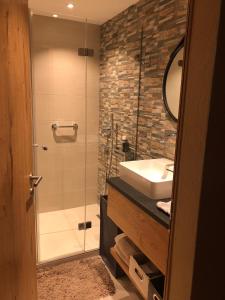y baño con ducha, lavabo y espejo. en Laax Flims Luxury Large apartment near Rock Resort en Laax-Murschetg