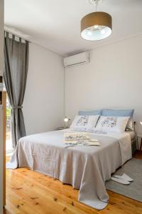 a white bed in a room with a window at Naftilos Blue View retreat in Avia