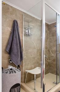 a bathroom with a shower with a glass door at Naftilos Blue View retreat in Avia